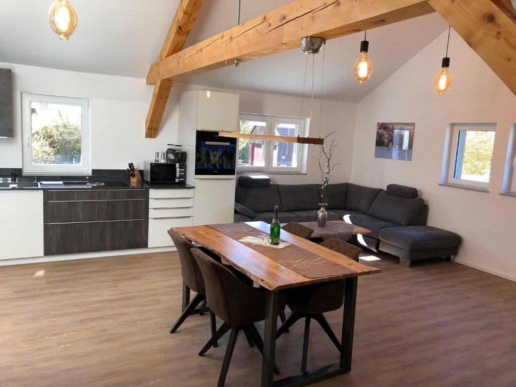 a living room with a wooden table and a kitchen at Zweizimmer-Apartment in Buchenberg