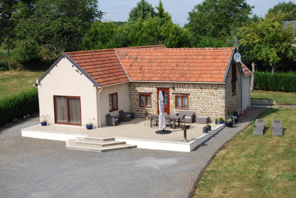 ein kleines Steinhaus mit einem Tisch und Stühlen in der Unterkunft Rural spacious bungalow with pool in Chalandrey