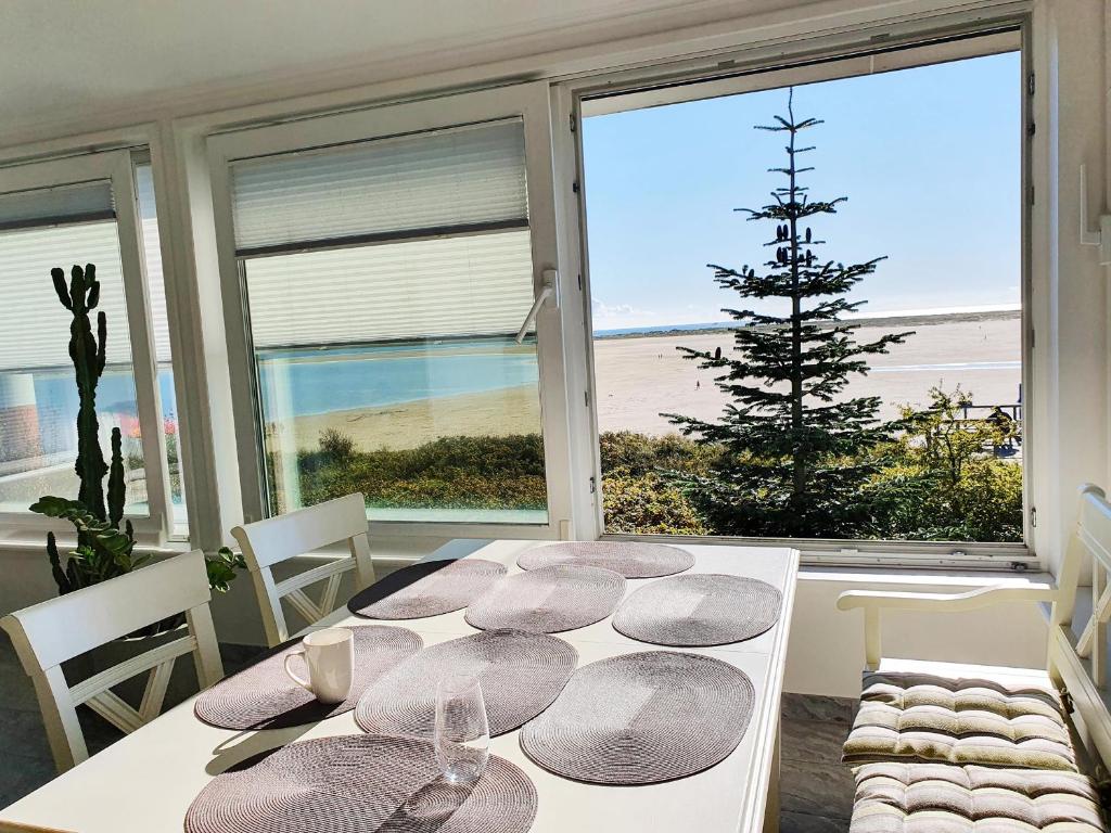 a dining room table with a view of the beach at Haus Kap Hoorn Ferienwohnung Gorch Fock in Wittdün