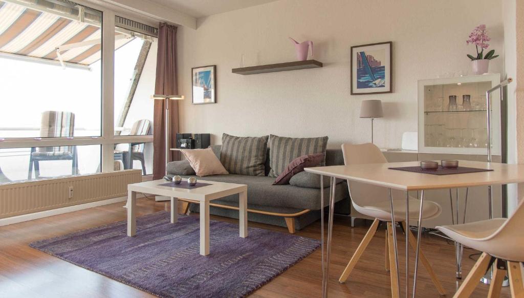 - un salon avec un canapé et une table dans l'établissement Ferienwohnung Oberdeck, à Schilksee