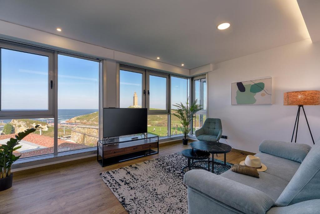 sala de estar con TV y ventanas grandes en TH Apartments by Como en Casa, en A Coruña