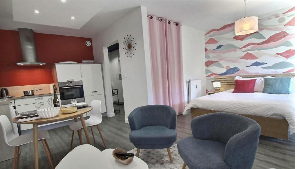 een slaapkamer met een bed en 2 stoelen en een tafel bij City Bagot in Saint-Brieuc