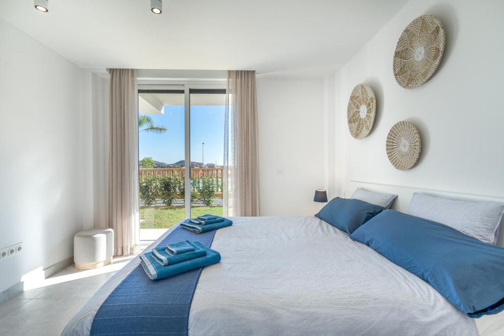 sypialnia z dużym łóżkiem z niebieskimi poduszkami w obiekcie Casa La Cala - Brand new apartment - La Cala de Mijas - Marbella - Malaga area 2 or 3 bedroom w mieście La Cala de Mijas