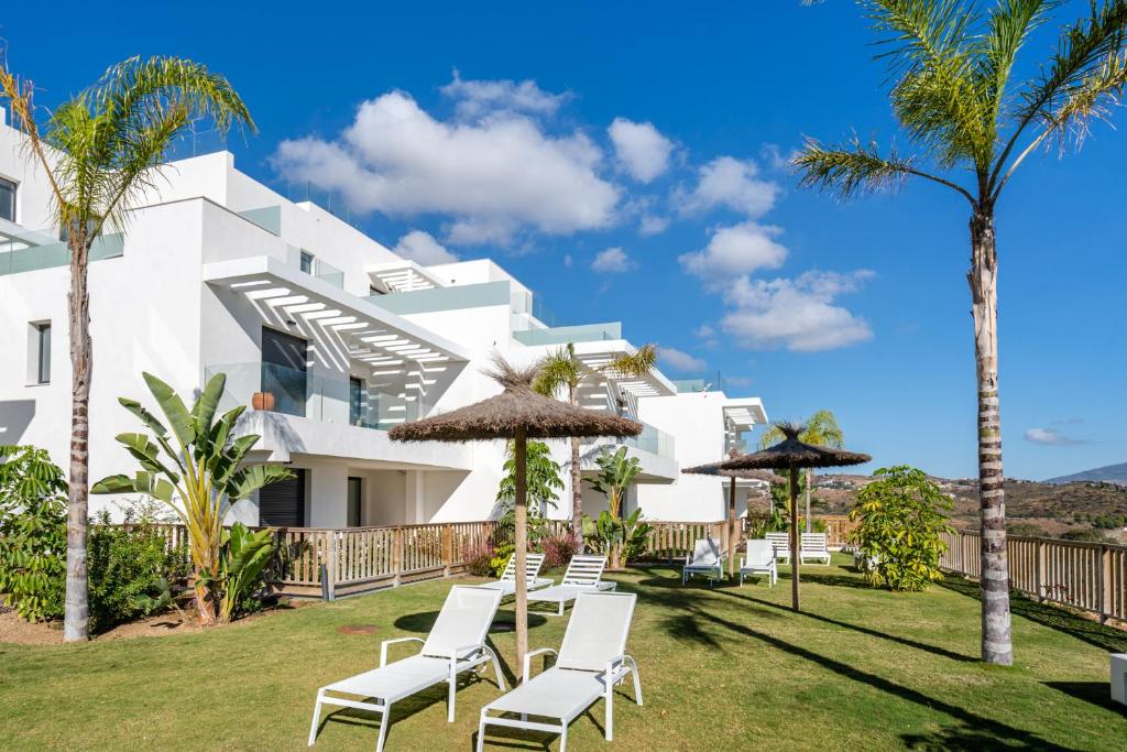 biały budynek z krzesłami i palmami w obiekcie Casa La Cala - Brand new apartment - La Cala de Mijas - Marbella - Malaga area 2 or 3 bedroom w mieście La Cala de Mijas