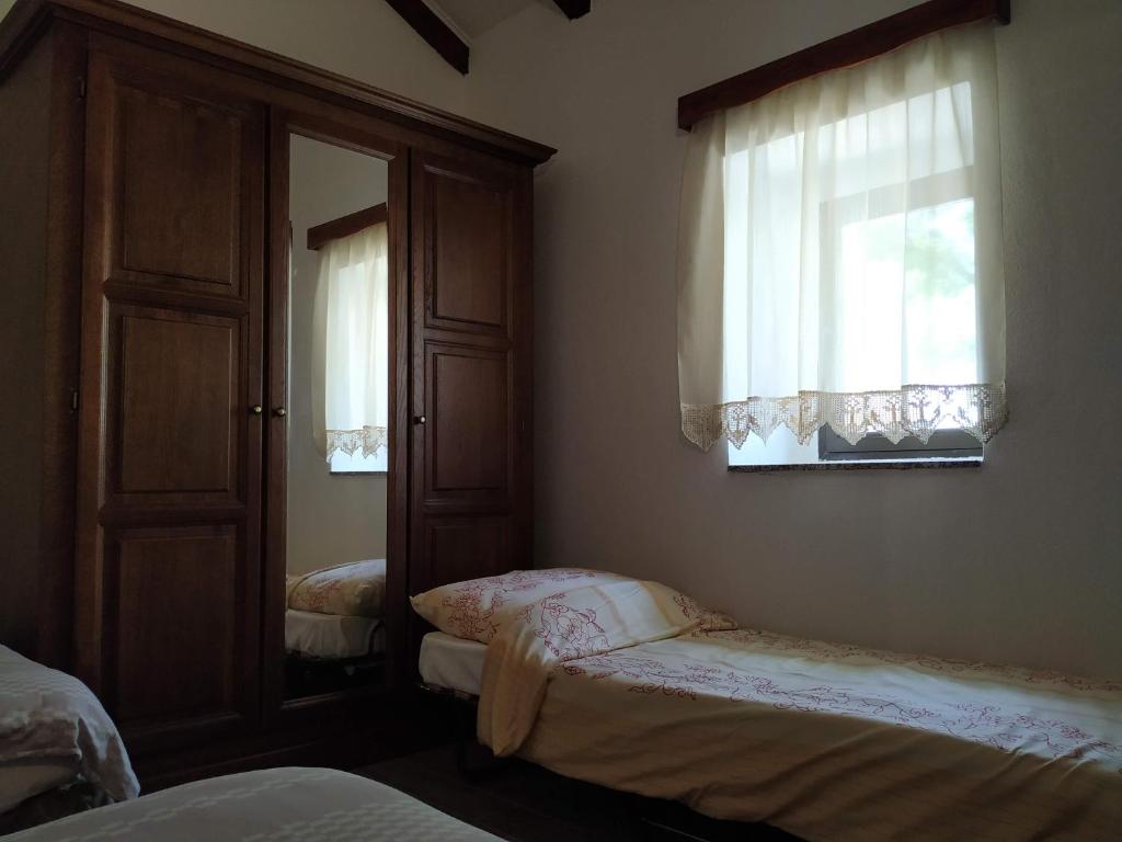 sypialnia z 2 łóżkami, lustrem i oknami w obiekcie Holiday home Cvita w mieście Starigrad-Paklenica