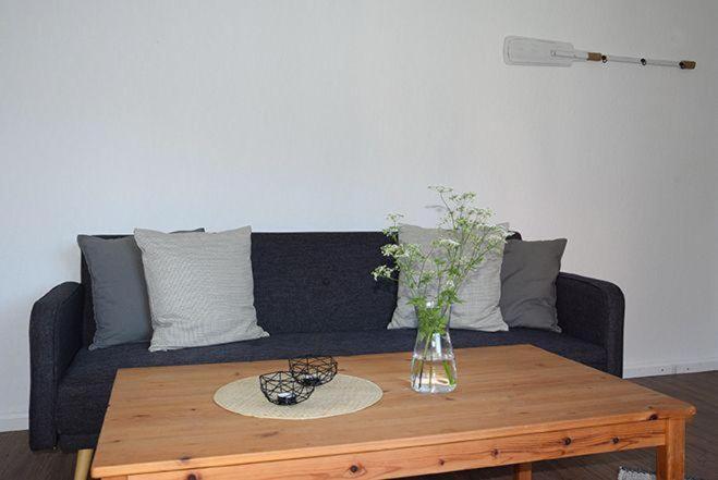 a living room with a black couch with a wooden coffee table at Moewe in Landkirchen