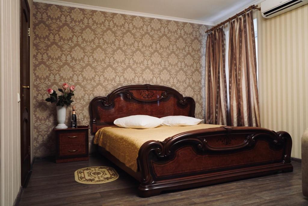 1 dormitorio con 1 cama y un jarrón de flores en Evropeyskiy, en Kiev
