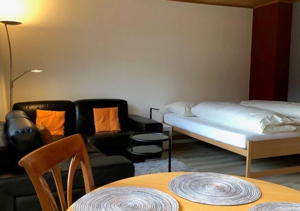 a living room with a bed and a couch at Appartementhaus Quadern (A302) in Valens