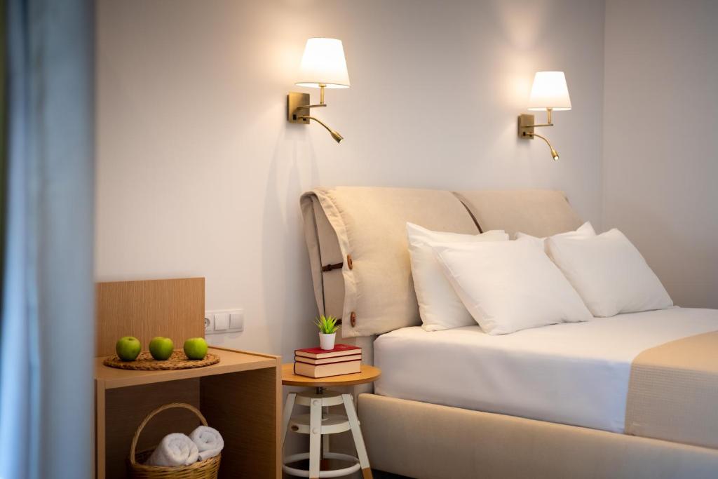 a bedroom with a bed and a table with a stool at Eutopia Olive Garden in Syvota
