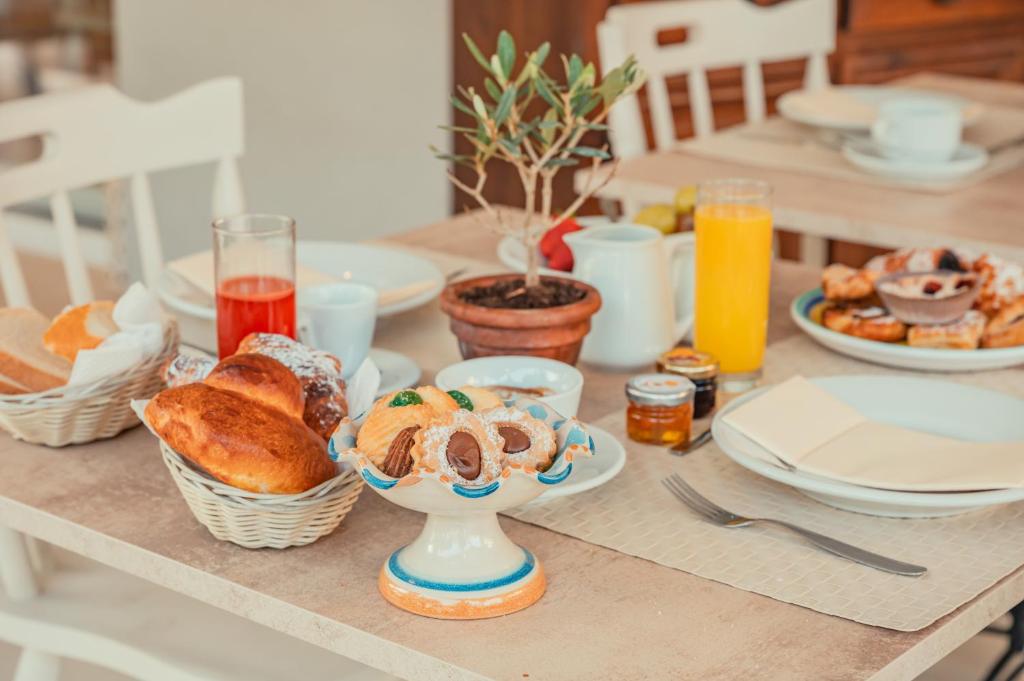 a table with a breakfast of bread and pastries at Hotel Rivage Taormina in Taormina