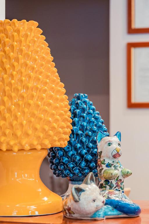 a figurine of a cat next to a yellow vase at Hotel Rivage Taormina in Taormina