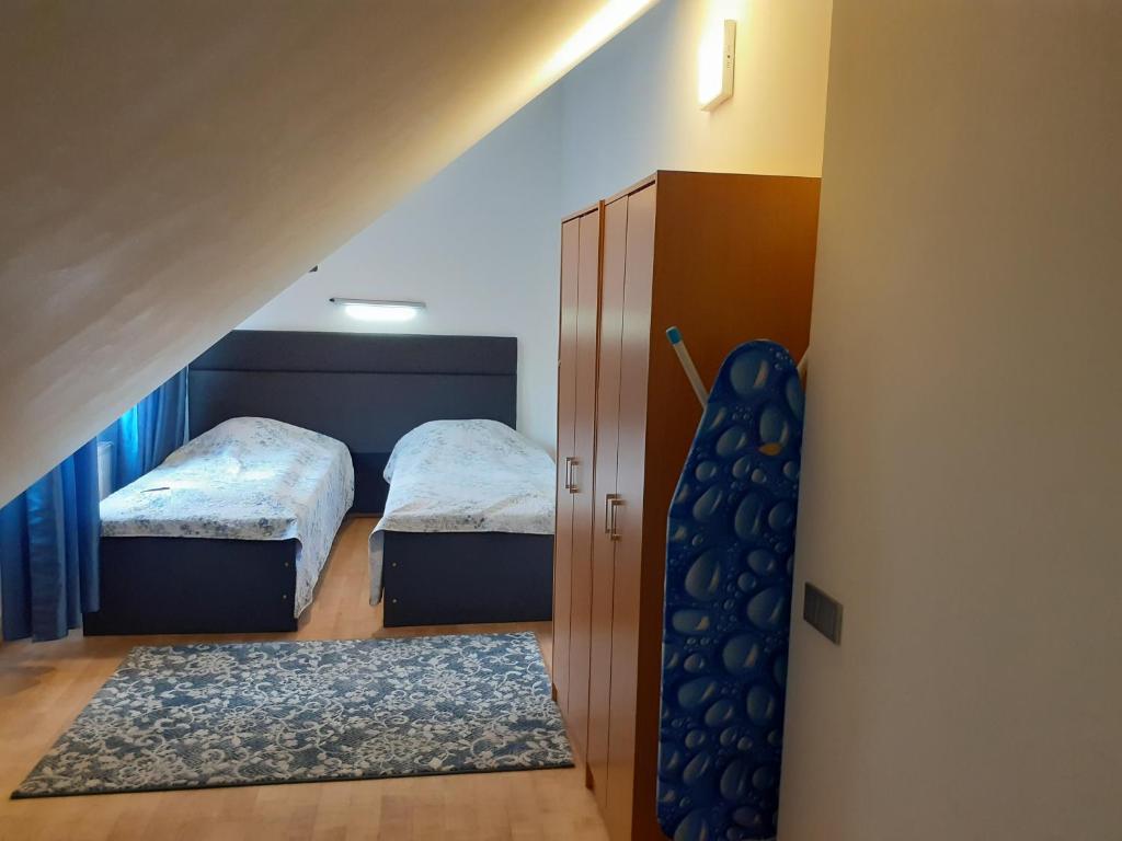 a small room with two beds and a staircase at Attic rooms at Laisves avenue in Kaunas