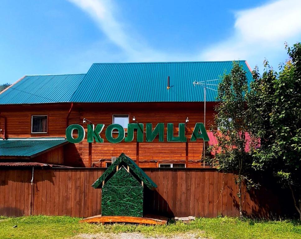 a wooden barn with a sign on the side of it at Hotel Complex Okolitsa in Uznezya