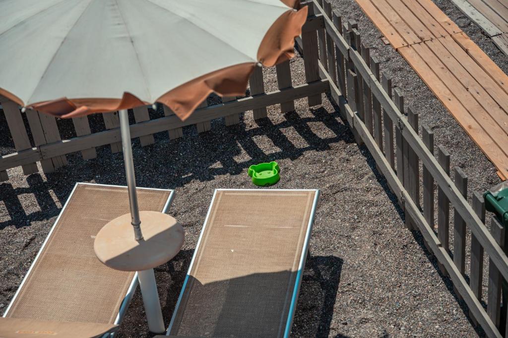a balcony with a table and an umbrella and a chair at Hotel Rivage Taormina in Taormina