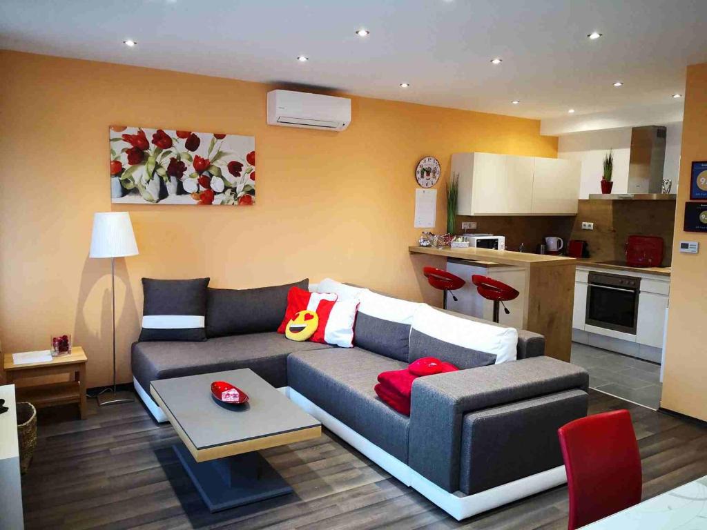 a living room with a couch and a kitchen at Zafír Sziget Apartman in Sárvár