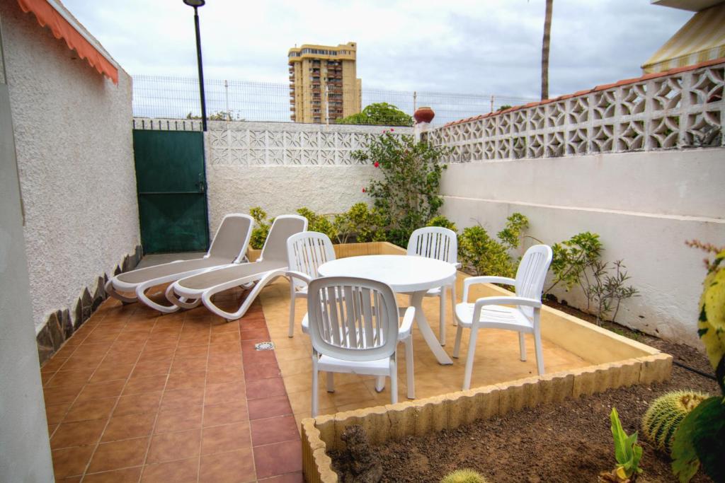 een patio met een tafel en stoelen op een balkon bij Casa Anna, cerca la playa in Arona