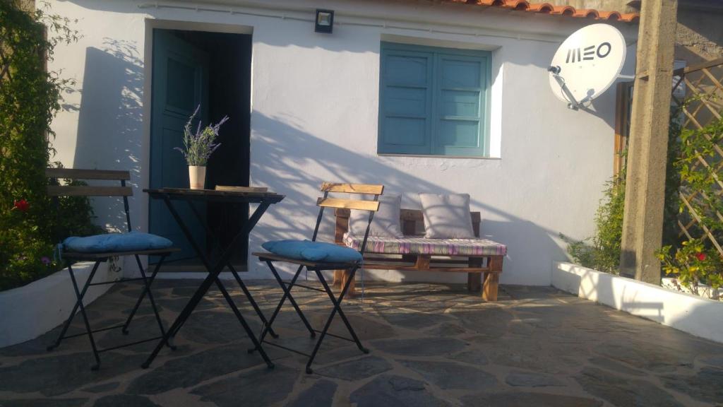 Monchique Typical House في مونشيك: كرسيين ومقعد امام المنزل