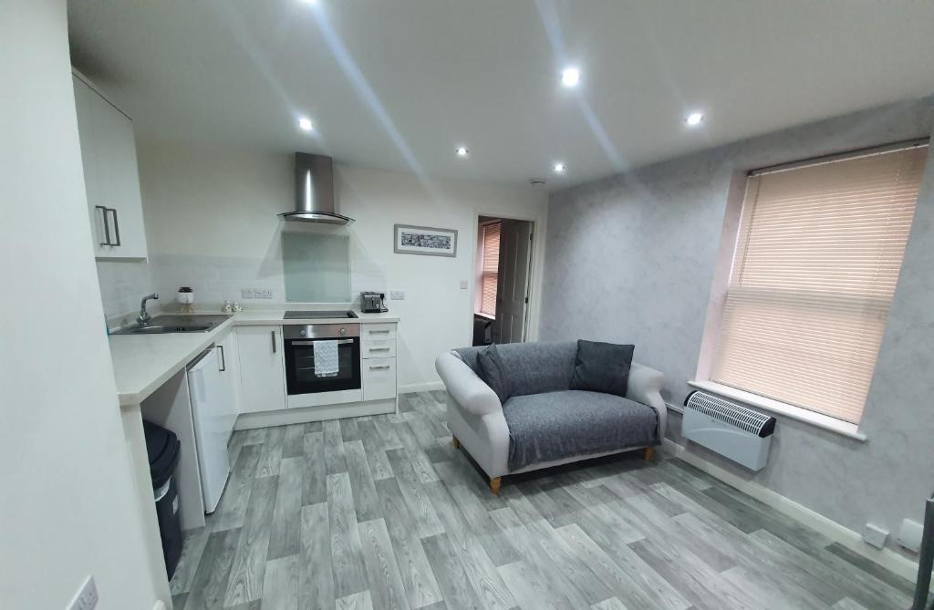 a kitchen with a couch and a chair in a room at No 1 new inn apartments NEWLY RENOVATED in Newark-on-Trent