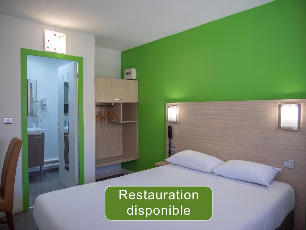 a bedroom with a bed with a green wall at Hotel Restaurant Les Jardins D'Epône in Épône