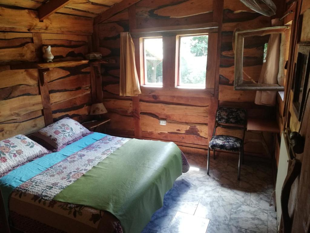 um quarto com uma cama num chalé de madeira em Cabañas Monje em Tandil