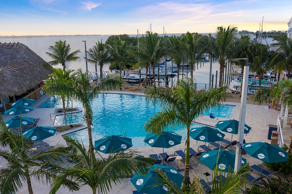 uma vista para uma piscina com guarda-sóis azuis em Compass Hotel by Margaritaville Anna Maria Sound em Bradenton