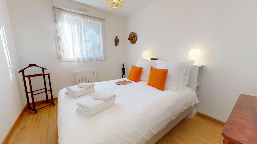 1 dormitorio con 1 cama blanca grande con almohadas de color naranja en Gîte Saint Josse 3 chambres en Colmar