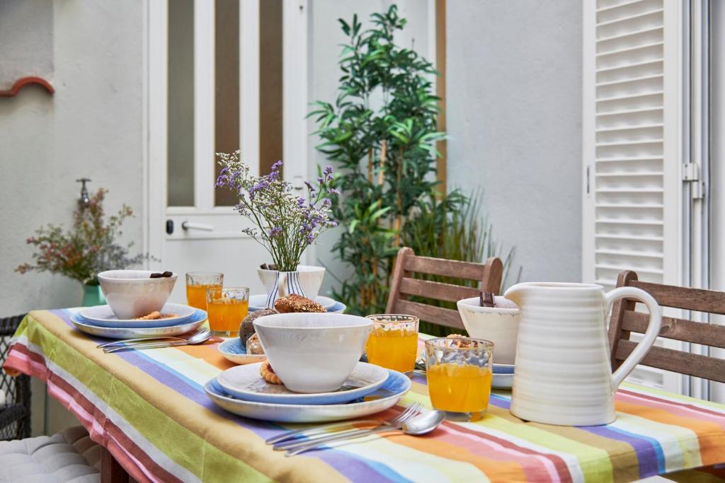 une table avec des assiettes et des tasses en haut dans l'établissement Spacious Bairro Alto Apartment With Courtyard, By TimeCooler, à Lisbonne