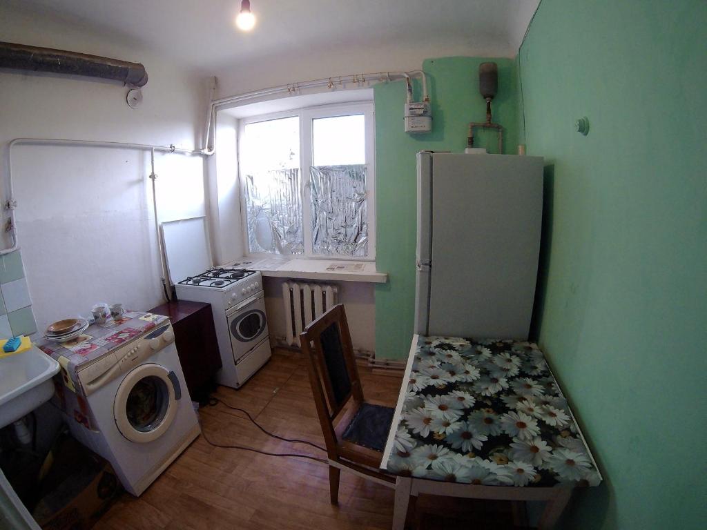 a small kitchen with a refrigerator and a window at однокомнатная квартира in Nova Kakhovka