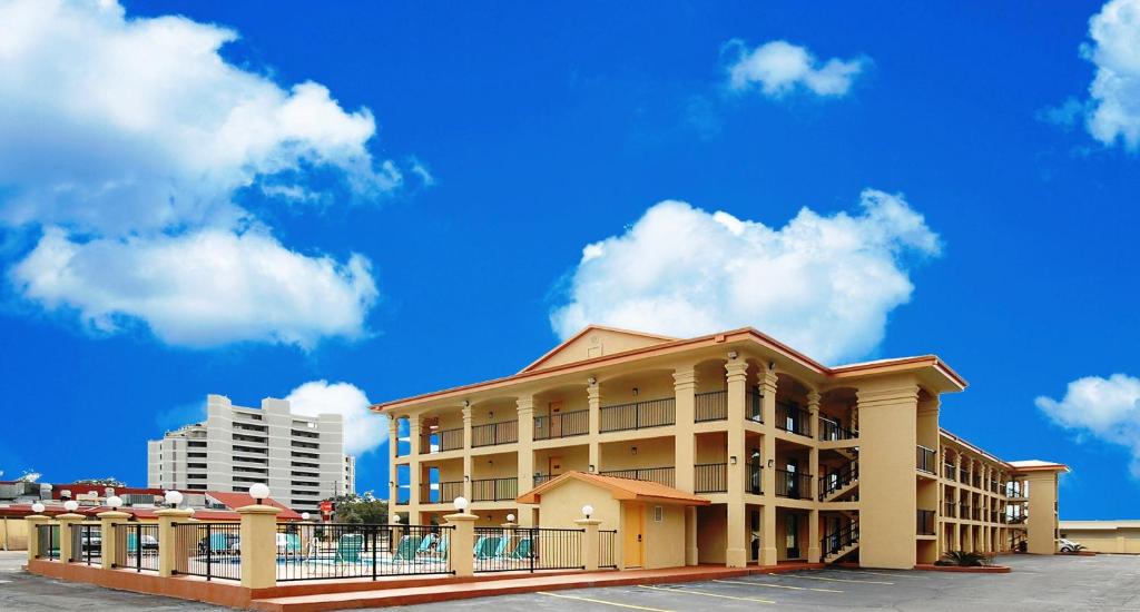 un edificio de hotel con cielo azul y nubes en Fairway Inn, en Fort Walton Beach