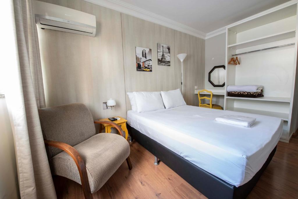 特雷索波利斯的住宿－Hotel Santiago Centro，配有一张床和一把椅子的酒店客房