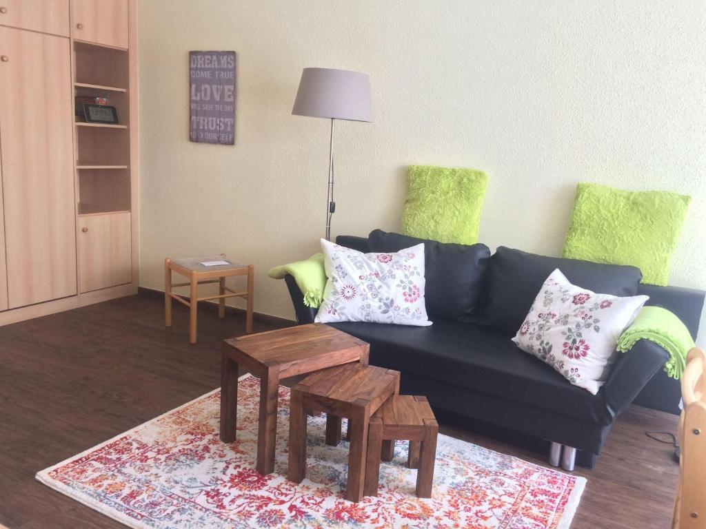 uma sala de estar com um sofá azul e uma mesa em Ferienwohnung-Koehler-2 em Altreichenau