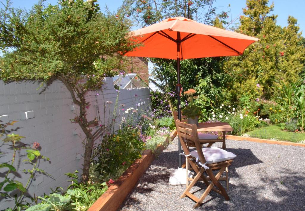 a table and chair under an umbrella in a garden at The Annexe in Bracknell
