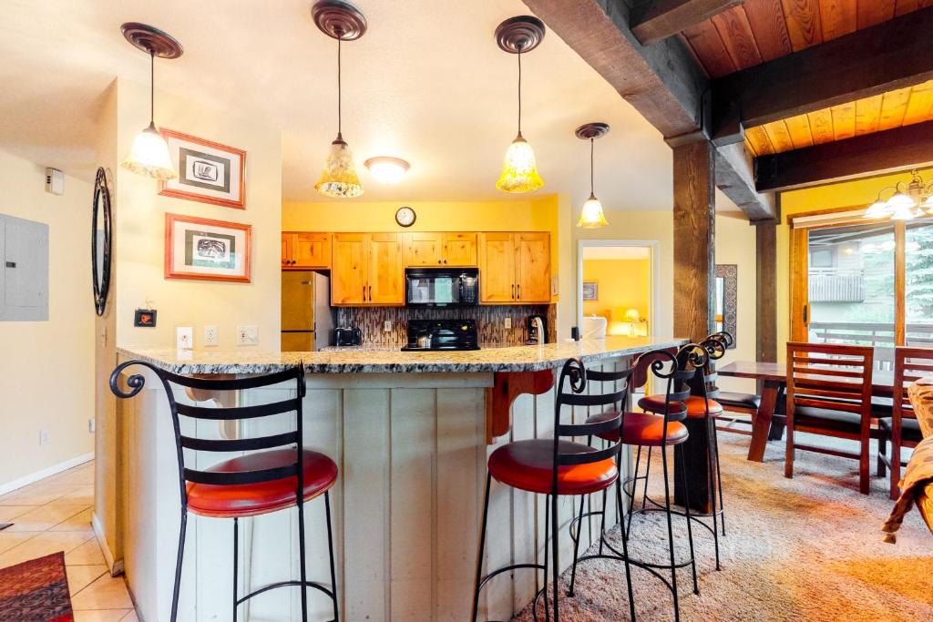 a kitchen with a bar with stools at The Lodge at Steamboat in Steamboat Springs