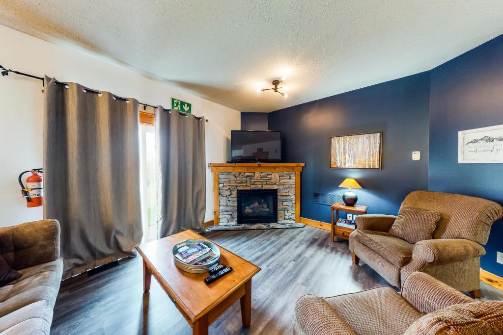 a living room with a couch and a fireplace at Condo 123 at Snowbridge in Blue Mountains