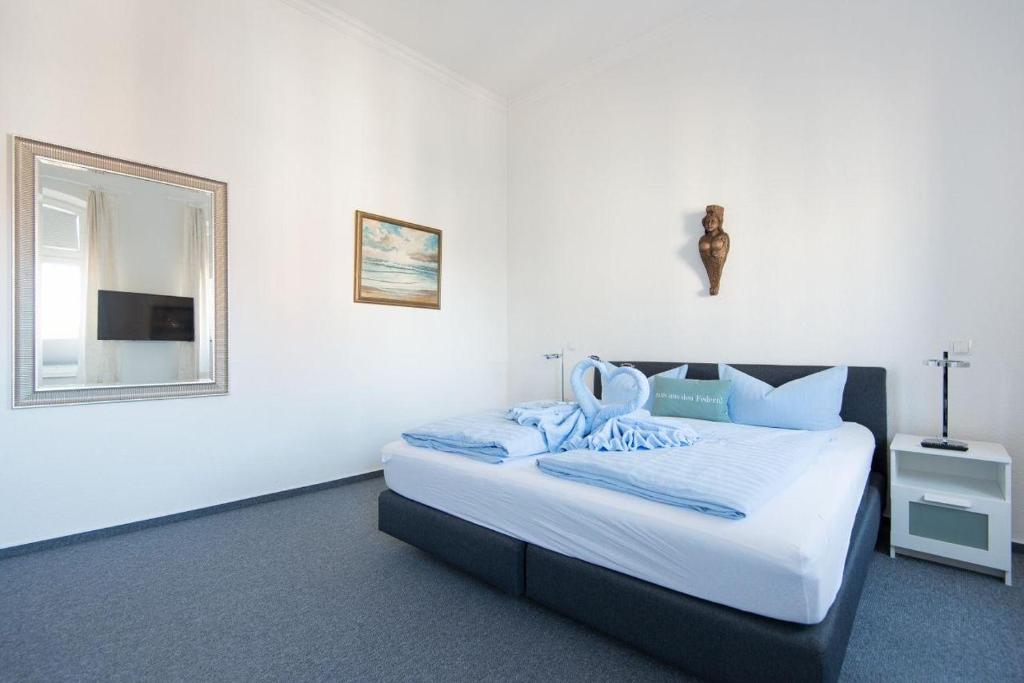 a bedroom with a bed with a mirror and a window at Kapitaenshaus-Lassen-Zimmer-Penelope in Westerland