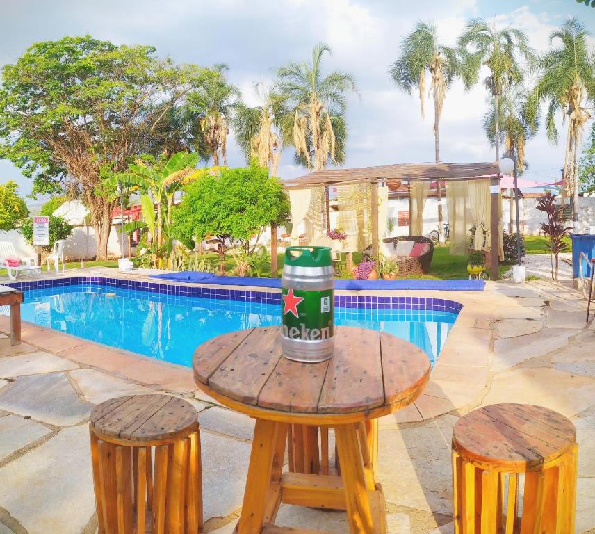 una mesa y dos taburetes frente a una piscina en Chalés e Camping Bela Vista, en Pirenópolis