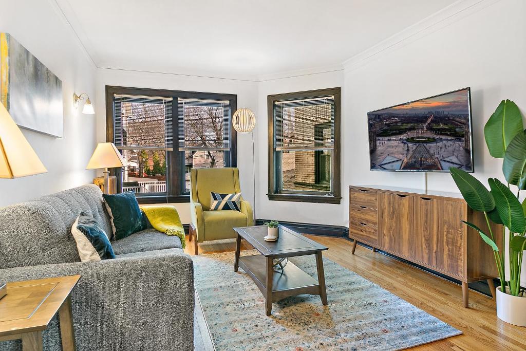 a living room with a couch and a table at Your 1BR Homey Haven in Vibrant Chicago - Larchmont 1A-3A in Chicago