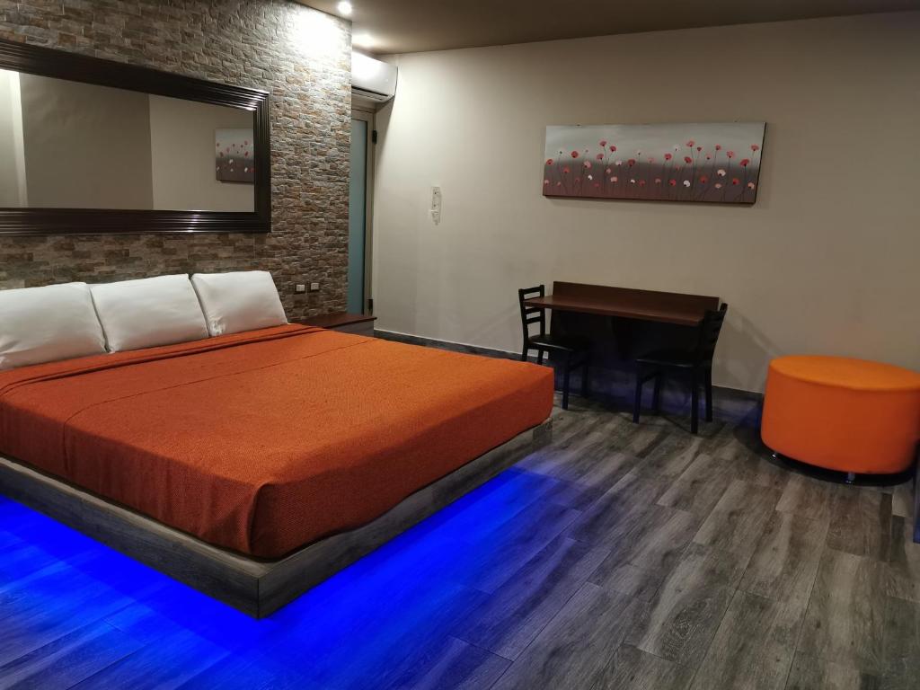 a bedroom with a bed and a desk and a table at Hotel Plaza Arteaga in Monterrey