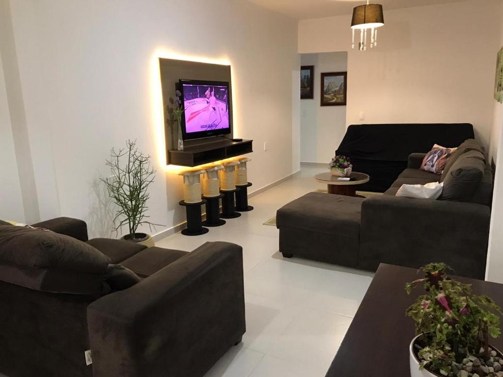 a living room with couches and a flat screen tv at Casa Walter in Balneário Camboriú
