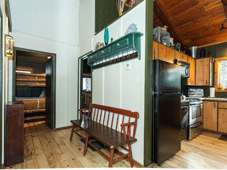 a kitchen with a bench and a refrigerator at Treehouse On The Stream Sundance, Utah in Sundance