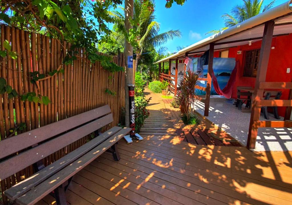 una terraza de madera con un banco junto a una valla en Pousada das Ilhas, en Fernando de Noronha