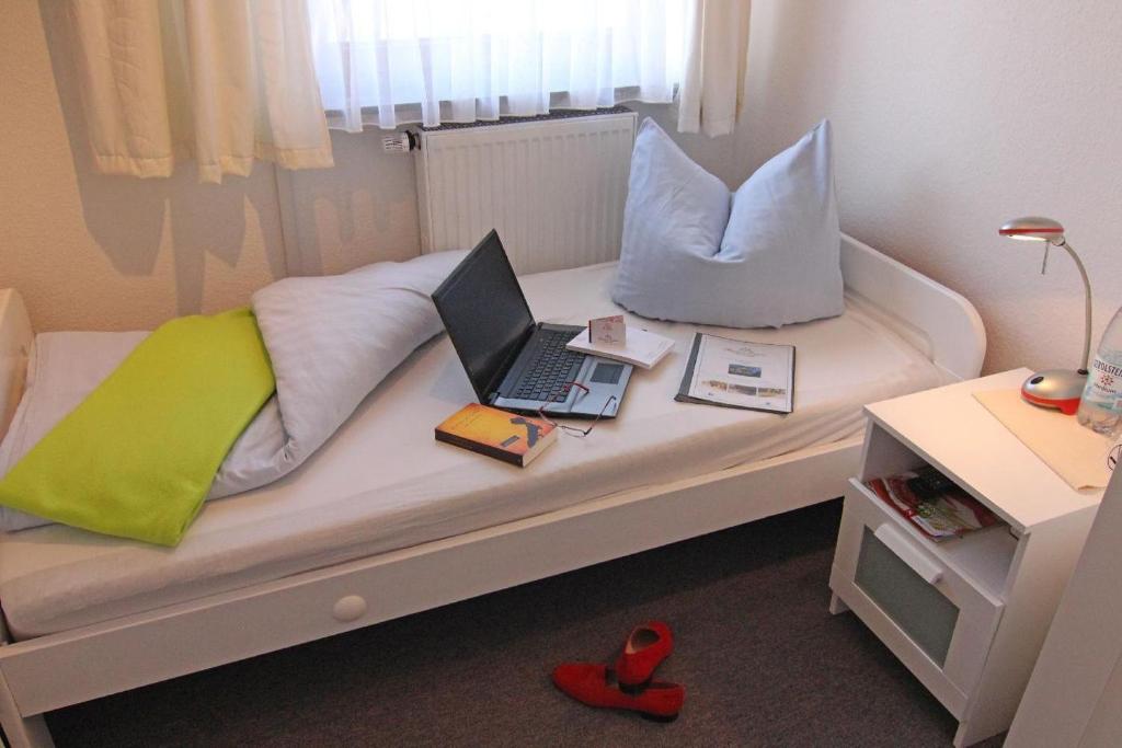 a bed with a laptop and pillows on it at Kapitaenshaus-Lassen-Zimmer-Kajuete in Westerland (Sylt)