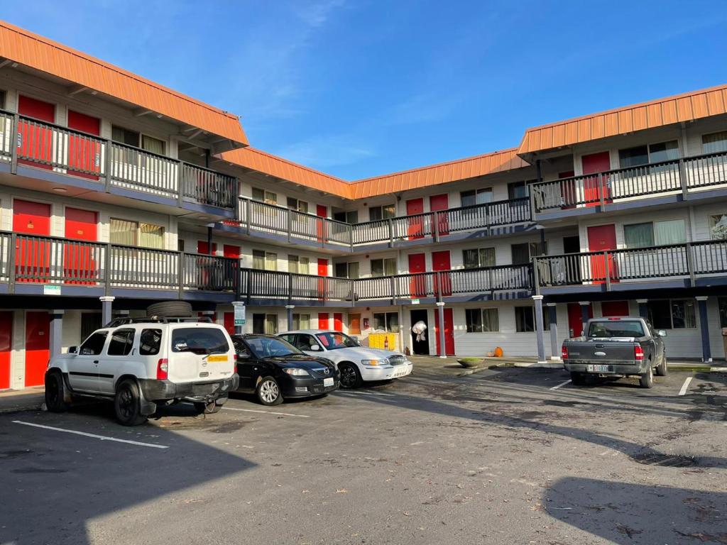 a parking lot with cars parked in front of a building at Portland Inn in Portland