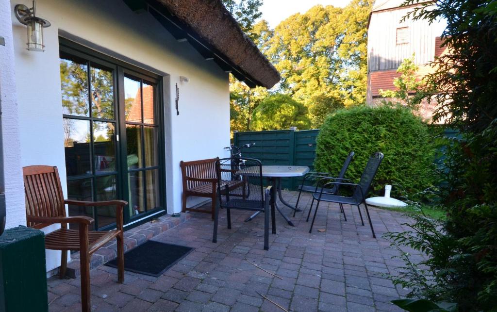 a patio with chairs and a table next to a building at Eck-Reethaus-Kirchhaus in Groß Zicker