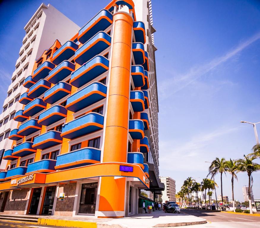 a colorful building with palm trees in front of it at Hotel Candilejas Playa in Veracruz