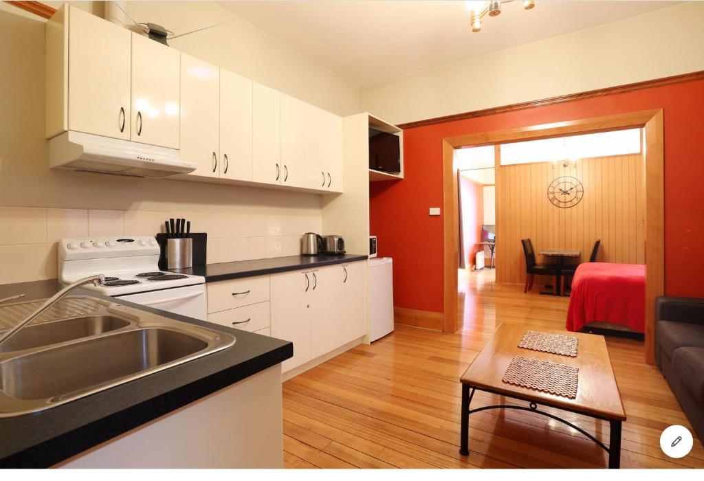 Il comprend une cuisine avec un évier et un salon. dans l'établissement NORD - North Hobart Apartments, à Hobart