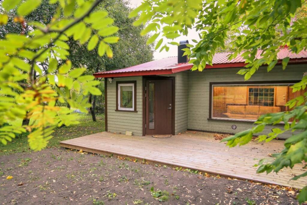 une petite maison avec une terrasse en bois devant elle dans l'établissement Baltic Getaway, à Käina