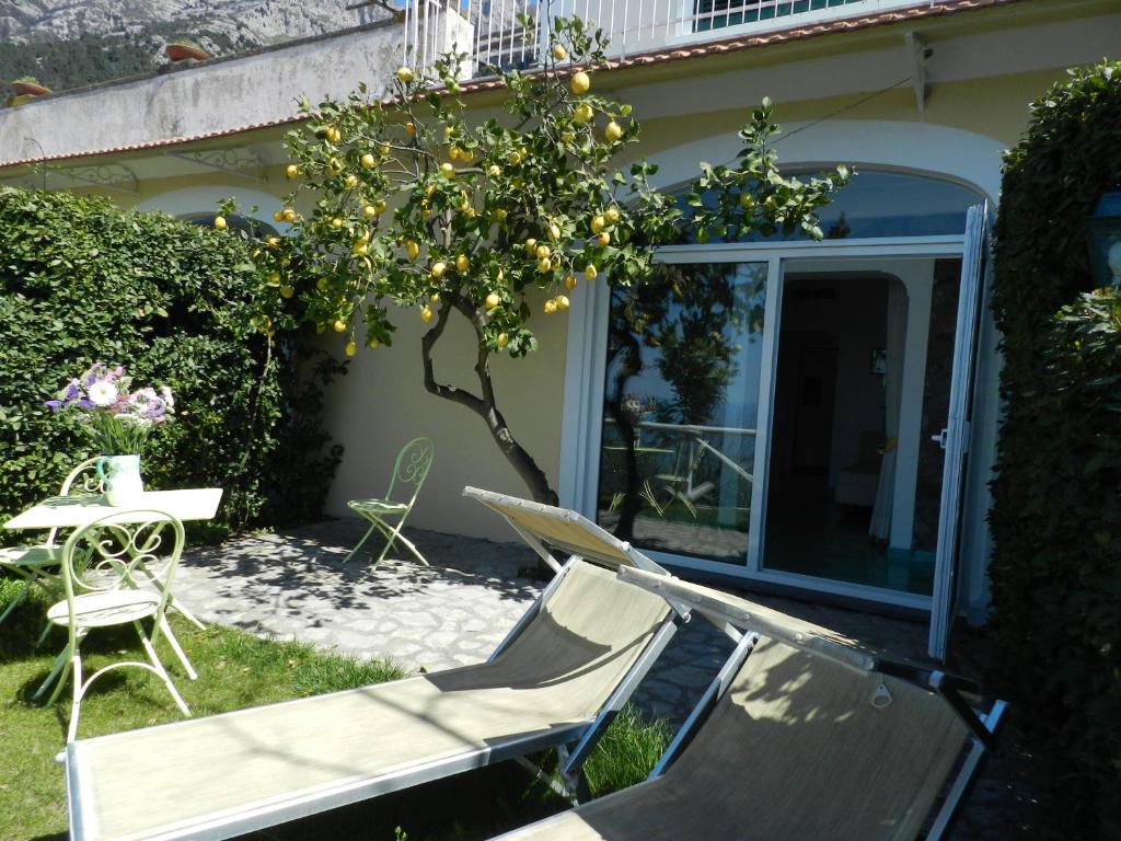 
a patio area with a bench and patio furniture at Bacio del Sole B&B Positano in Positano

