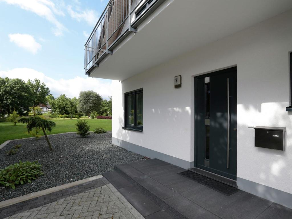 a white house with a black door and a courtyard at Serene Villa in Medebach K stelberg near Lake in Medebach