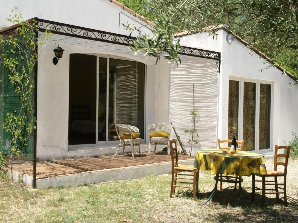 een terras met een tafel en stoelen bij Pretty house 30 minutes from the beach in Vergèze